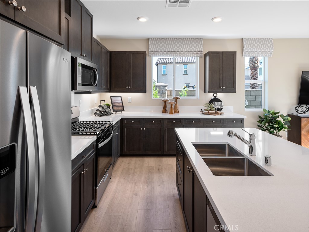 10294 Surge Lane Riverside, CA 92503 - Photo 1 of 1 a kitchen with stainless steel appliances a sink stove and refrigerator