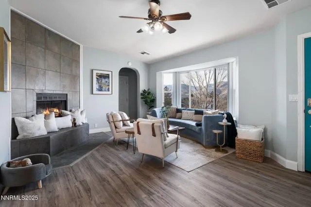 a living room with fireplace furniture and a large window