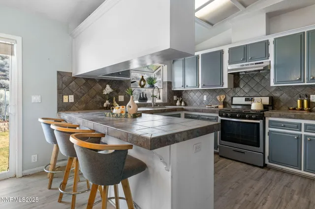 a kitchen with granite countertop a sink chairs and cabinets
