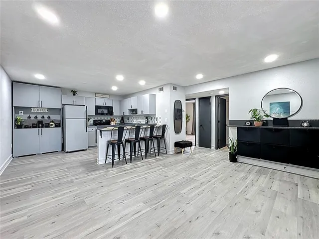 a kitchen with refrigerator and chairs