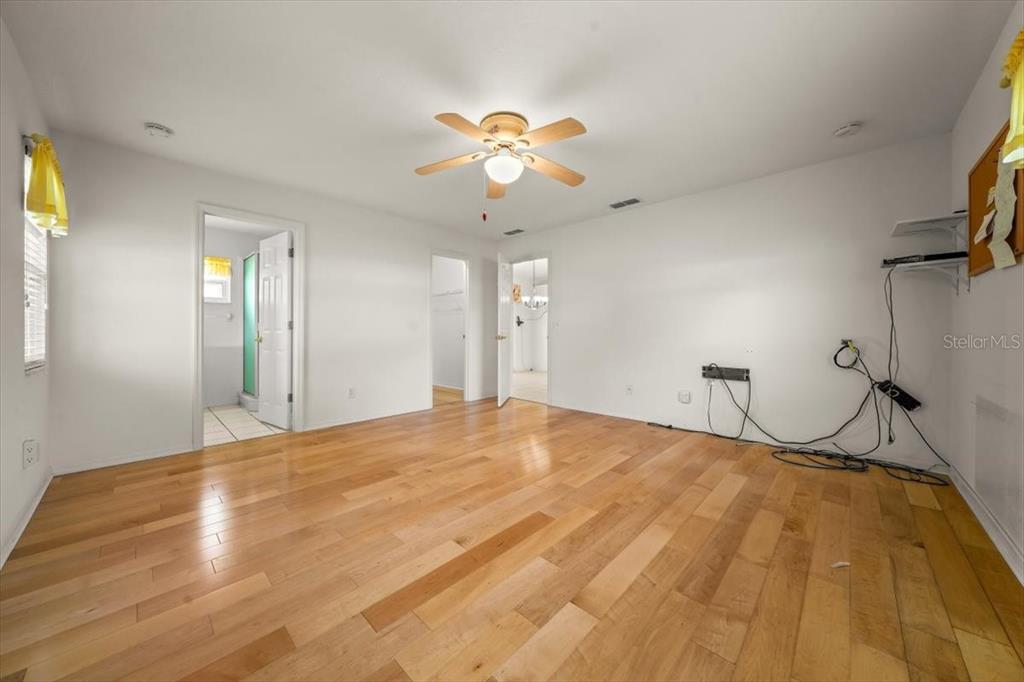 6145 Southwest 100th Loop Ocala, FL 34476 - Photo 33 of 54 a bedroom with a bed and a chandelier