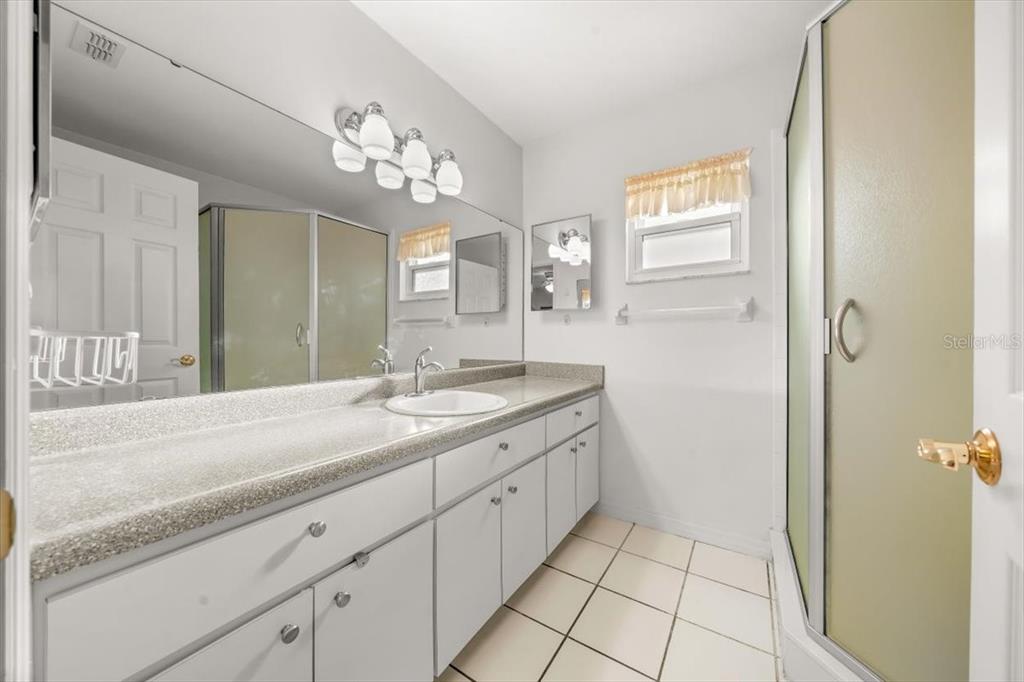 6145 Southwest 100th Loop Ocala, FL 34476 - Photo 35 of 54 a spacious bathroom with a granite countertop sink a mirror and a shower