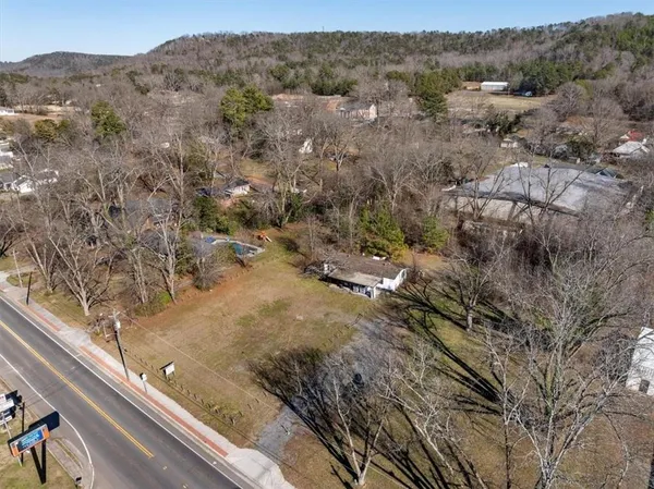 an aerial view of residential houses with outdoor space and trees