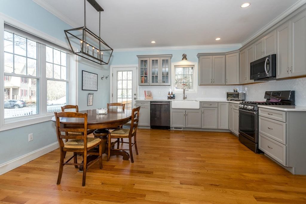 59 Endicott Street, Unit 59 Canton, MA 02021 - Photo 6 of 20 a kitchen with stainless steel appliances granite countertop wooden floor a dining table and chairs