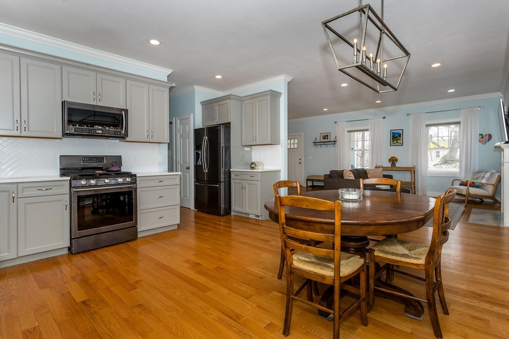 59 Endicott Street, Unit 59 Canton, MA 02021 - Photo 8 of 20 a kitchen with stainless steel appliances a dining table chairs stove and microwave