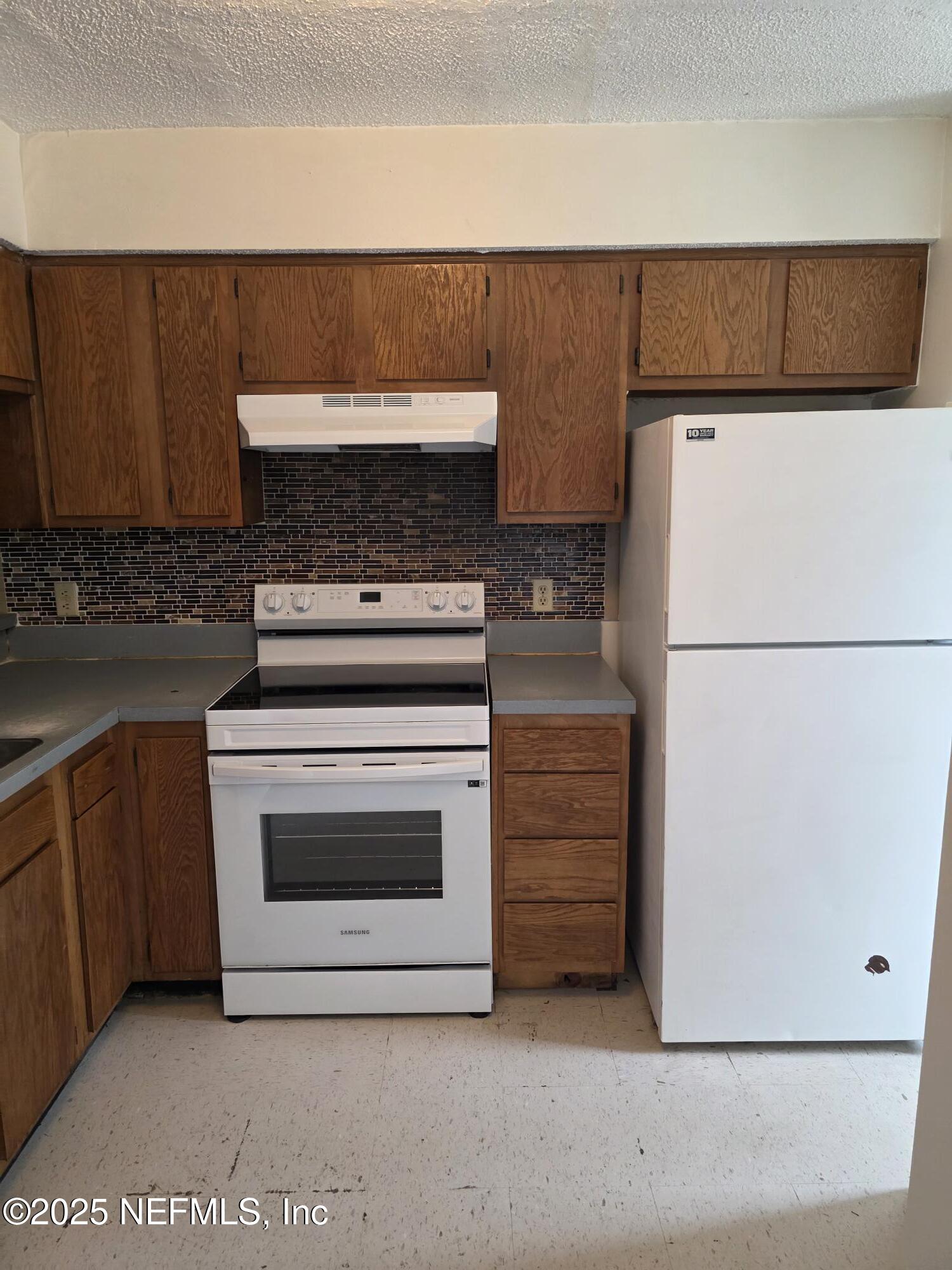4641 Barnes Road South Jacksonville, FL 32207 - Photo 11 of 12 a kitchen with a stove and a refrigerator