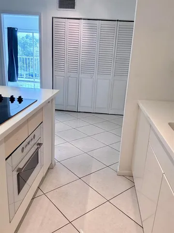 a view of a kitchen with dishwasher and white cabinets with wooden floor