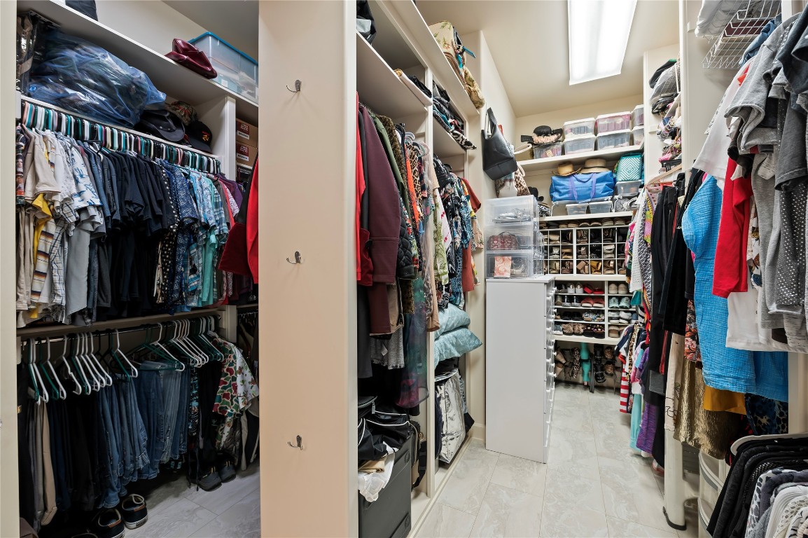 2201 Water Way Seabrook, TX 77586 - Photo 22 of 48 Spacious walk-in closet with ample shelving and hanging space, neatly organized for clothing, shoes, and accessories. Bright lighting and tiled flooring enhance the functional layout.