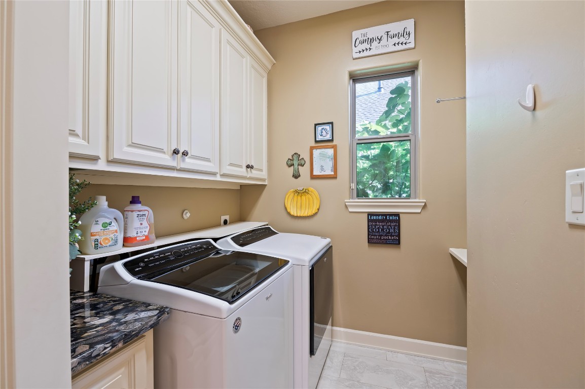 2201 Water Way Seabrook, TX 77586 - Photo 28 of 48 This laundry room features ample cabinet storage, and a window for natural light. It has a clean, organized design with decorative touches for a cozy feel.