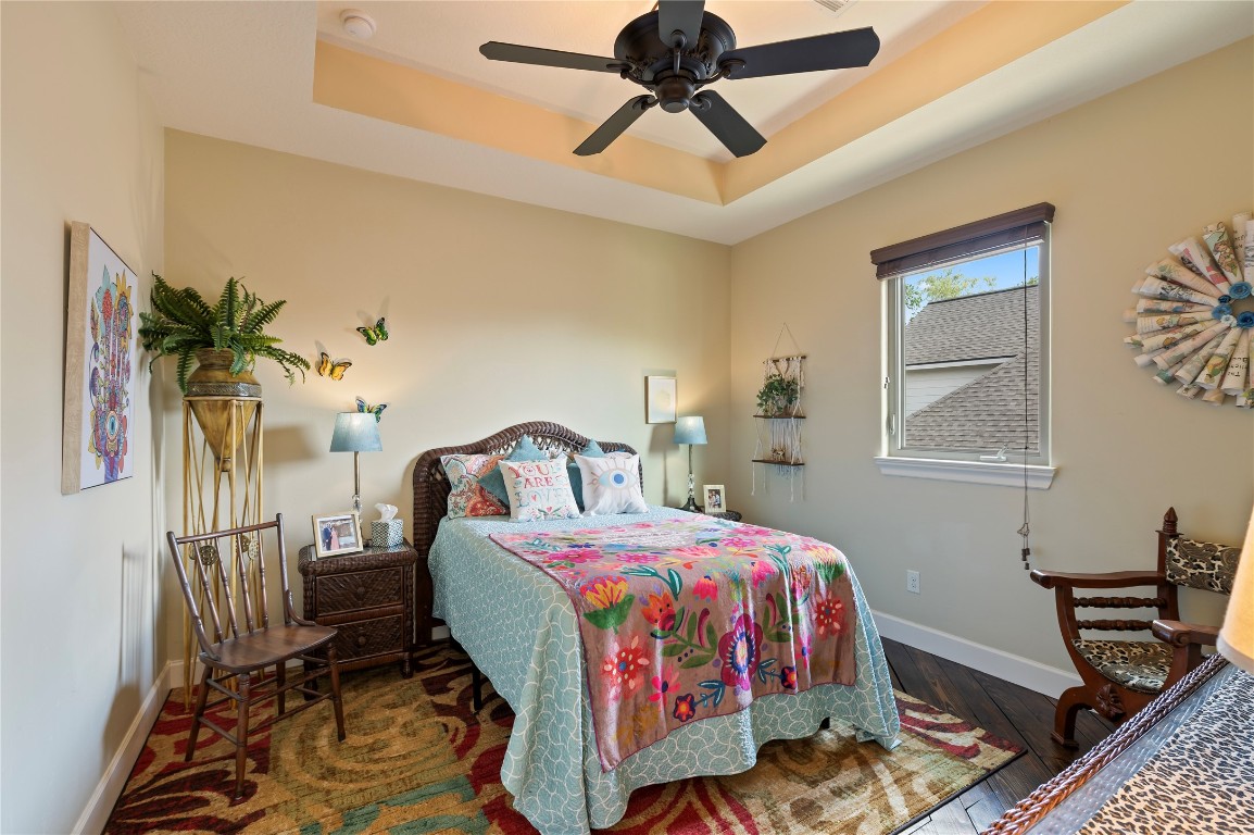 2201 Water Way Seabrook, TX 77586 - Photo 30 of 48 This cozy upstairs secondary bedroom features a tray ceiling with a ceiling fan, a large window for natural light, creating a welcoming and colorful atmosphere.