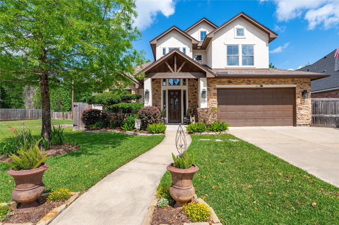 2201 Water Way Seabrook, TX 77586 - Photo 4 of 48 This is a charming two-story home featuring a modern exterior with a mix of stucco and stone, a well-maintained front yard with lush greenery, and a spacious driveway leading to a two-car garage.
