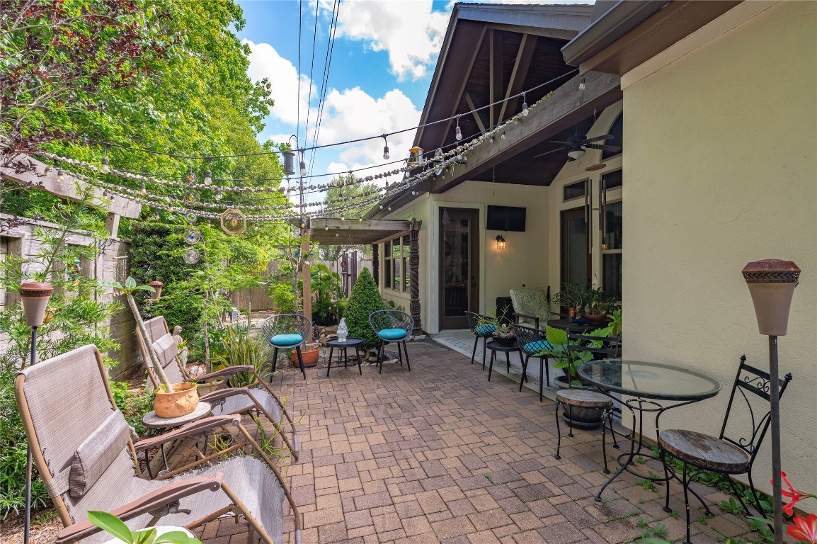 2201 Water Way Seabrook, TX 77586 - Photo 41 of 48 Charming patio with a cozy, rustic feel featuring string lights, comfortable seating, and lush greenery. Perfect for outdoor relaxation and entertaining, with a pergola providing shade and ambiance.