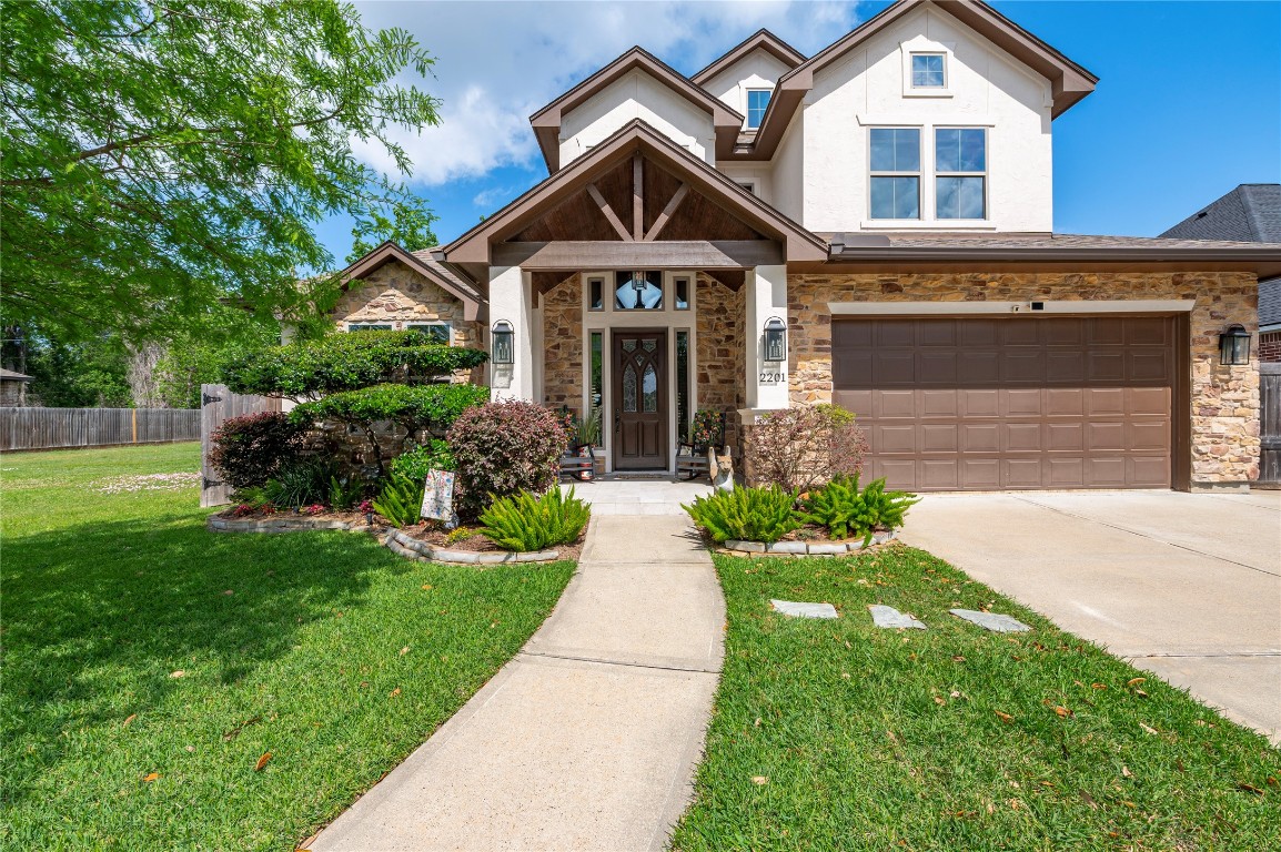 2201 Water Way Seabrook, TX 77586 - Photo 5 of 48 This charming two-story home features a stone and stucco exterior with a covered entryway. The well-maintained front yard includes lush landscaping and a curved walkway leading to the front door. A spacious double garage complements the inviting facade.