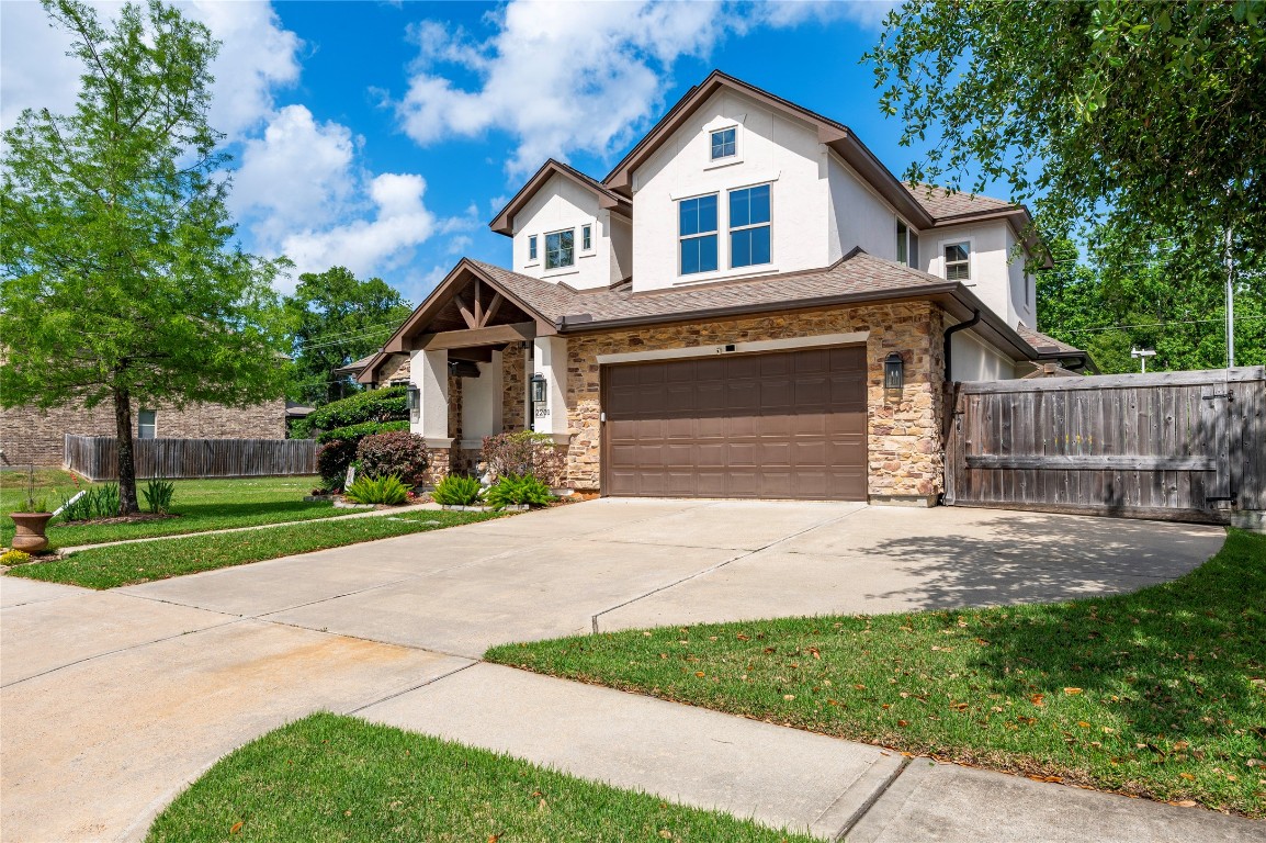 2201 Water Way Seabrook, TX 77586 - Photo 6 of 48 This photo showcases a charming two-story home with a stone and stucco facade, featuring a double garage. The property includes a well-maintained lawn, landscaped garden beds, and a spacious driveway, set in a serene neighborhood.