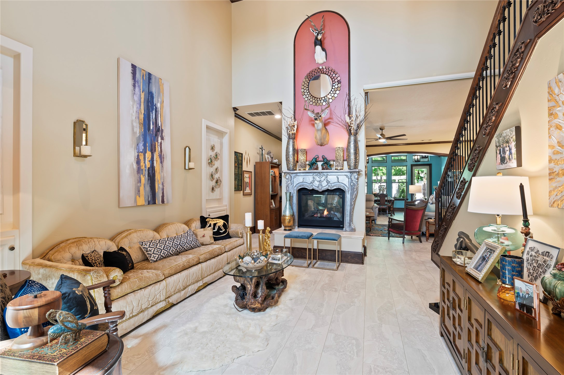 2201 Water Way Seabrook, TX 77586 - Photo 8 of 48 This is a spacious living room with a high ceiling and elegant decor. It features a grand fireplace with artistic details and a stylish staircase. The room is filled with natural light, enhancing its warm and inviting atmosphere.