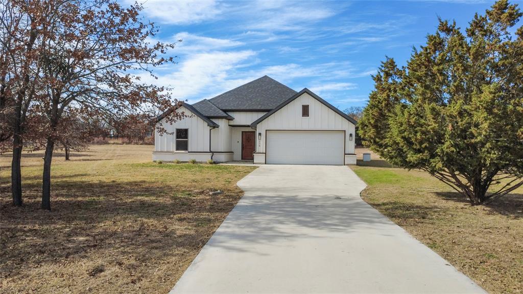 116 Grey Hound Lane Poolville, TX 76487 - Photo 1 of 16 a front view of a house with garden