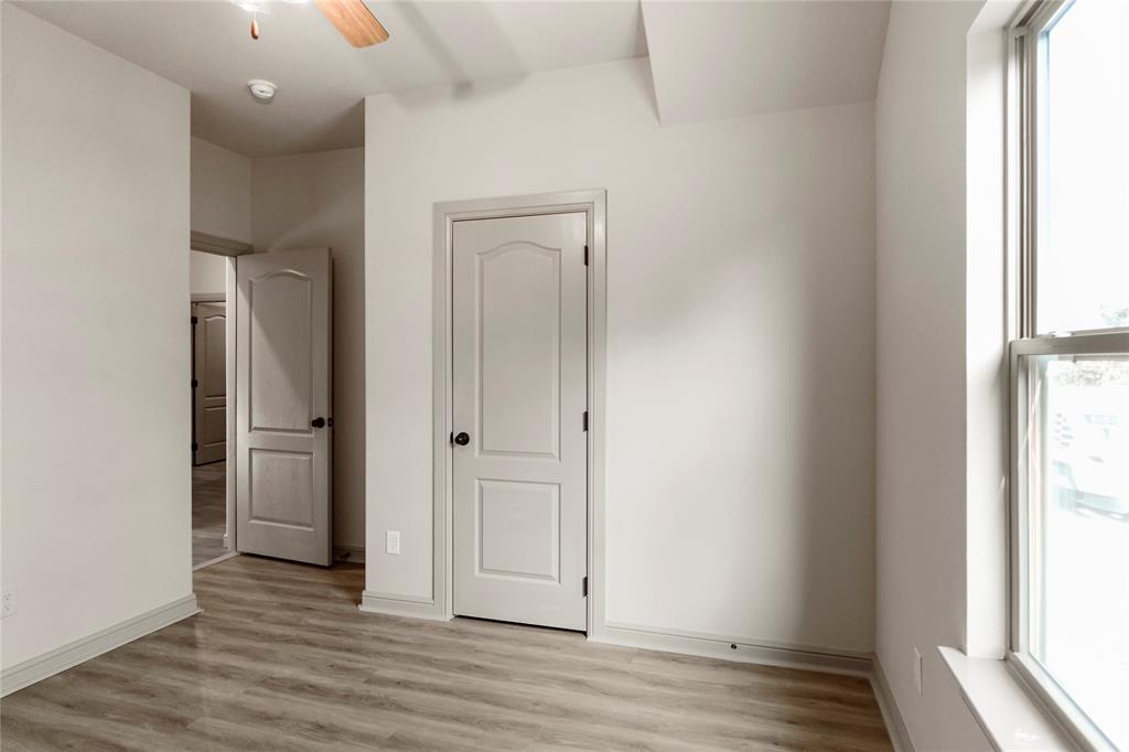 116 Grey Hound Lane Poolville, TX 76487 - Photo 13 of 16 an empty room with wooden floor and windows