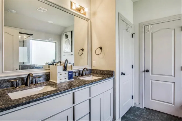a bathroom with double sink and a mirror