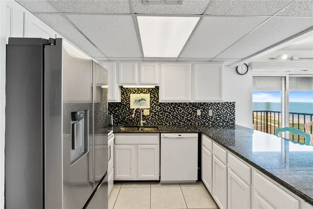 a kitchen with white cabinets and refrigerator