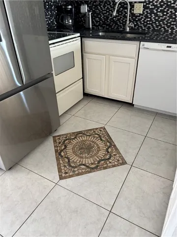a kitchen with white cabinets and white appliances