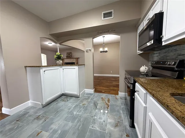 a kitchen with granite countertop a sink and a stove top oven