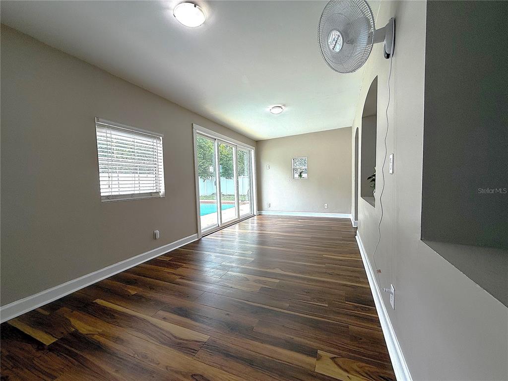 2924 Conway Gardens Road Orlando, FL 32806 - Photo 17 of 36 a view of an empty room with wooden floor and a window