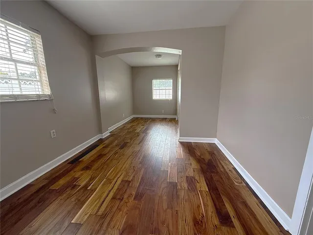 a view of a room with wooden floors and window