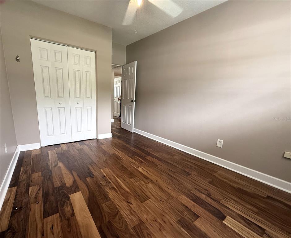 2924 Conway Gardens Road Orlando, FL 32806 - Photo 21 of 36 a view of an empty room with wooden floor and a window