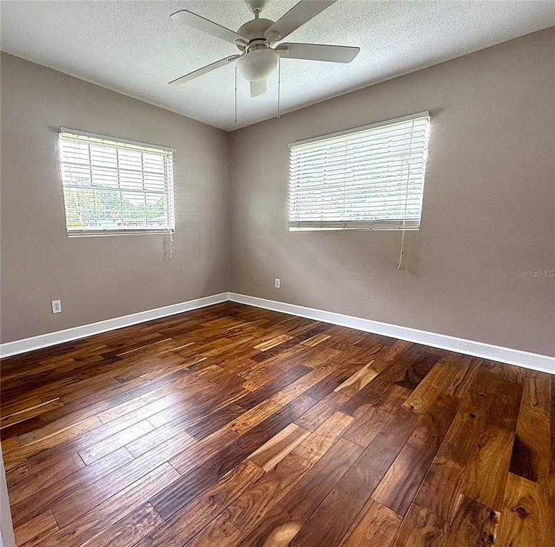 2924 Conway Gardens Road Orlando, FL 32806 - Photo 22 of 36 a view of empty room with wooden floor and fan