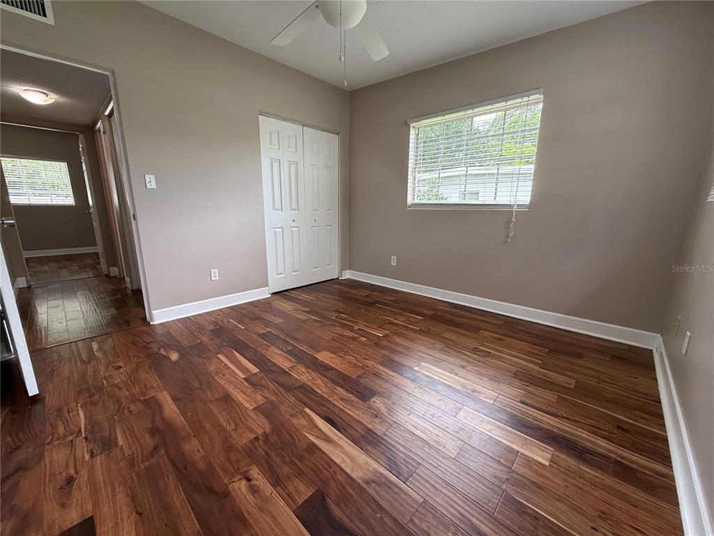 2924 Conway Gardens Road Orlando, FL 32806 - Photo 23 of 36 an empty room with wooden floor and windows