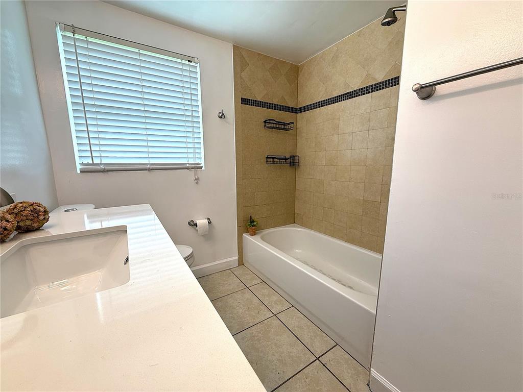 2924 Conway Gardens Road Orlando, FL 32806 - Photo 25 of 36 a bathroom with a tub a sink and a shower