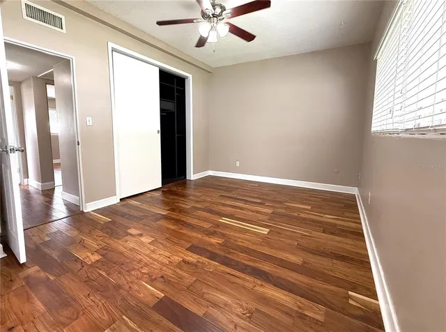 en empty room with wooden floor and windows