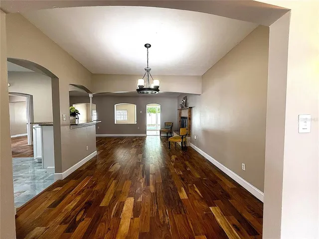 a view of a room with wooden floor chandelier and entryway