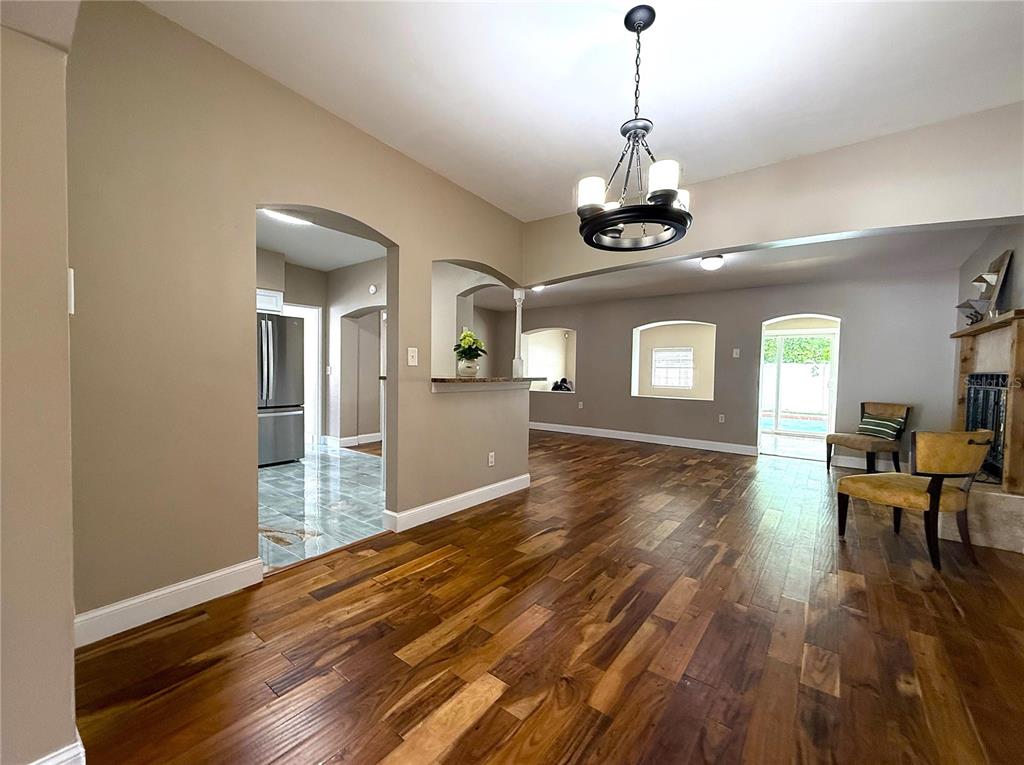 2924 Conway Gardens Road Orlando, FL 32806 - Photo 6 of 36 a view of a room with wooden floor a chandelier