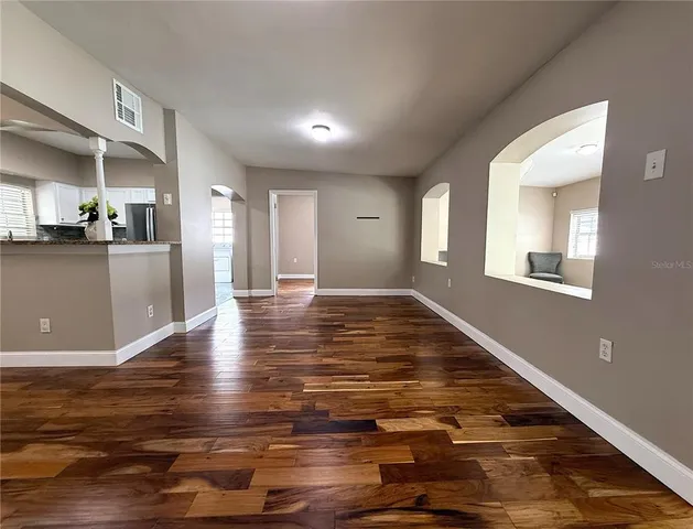 a view of a kitchen with kitchen island a sink wooden floor and a dining table