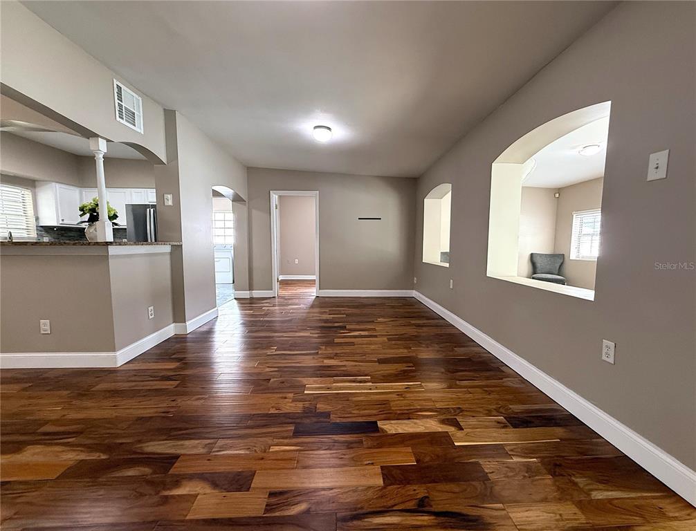 2924 Conway Gardens Road Orlando, FL 32806 - Photo 8 of 36 a view of a kitchen with kitchen island a sink wooden floor and a dining table
