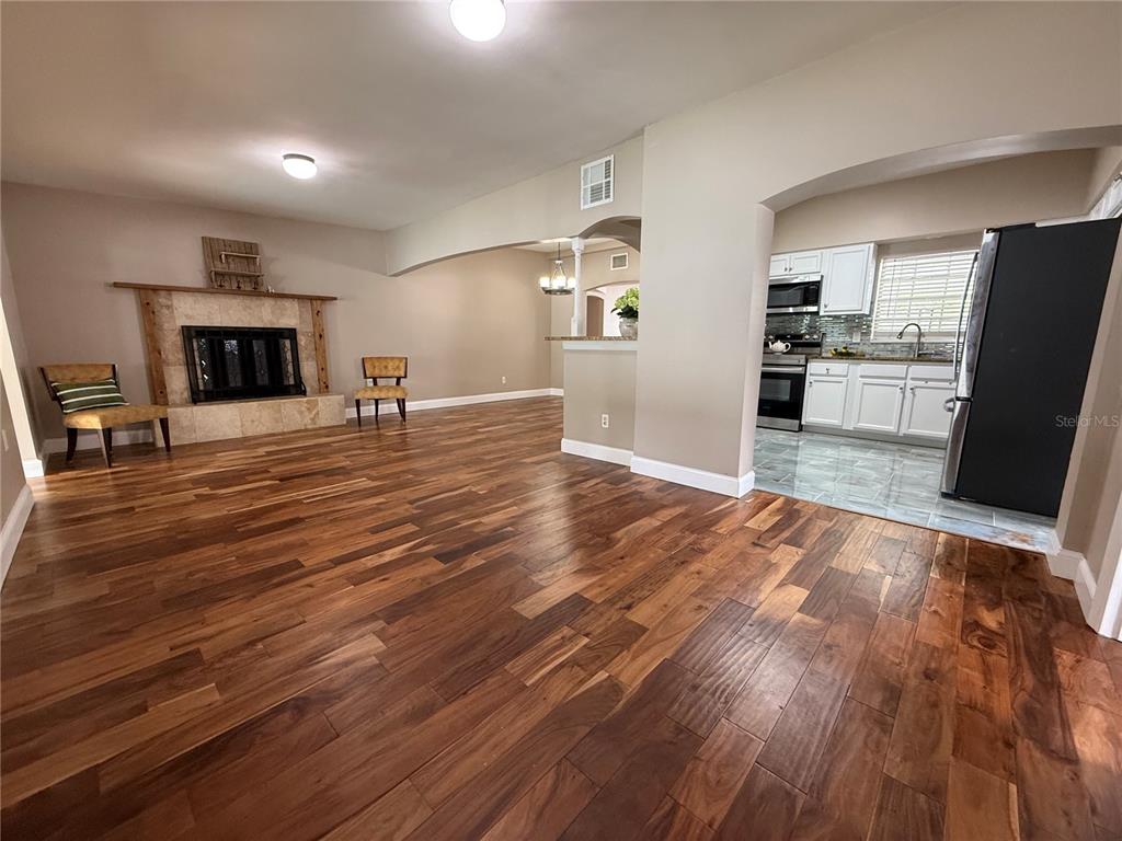 2924 Conway Gardens Road Orlando, FL 32806 - Photo 9 of 36 an empty room with wooden floor and fireplace
