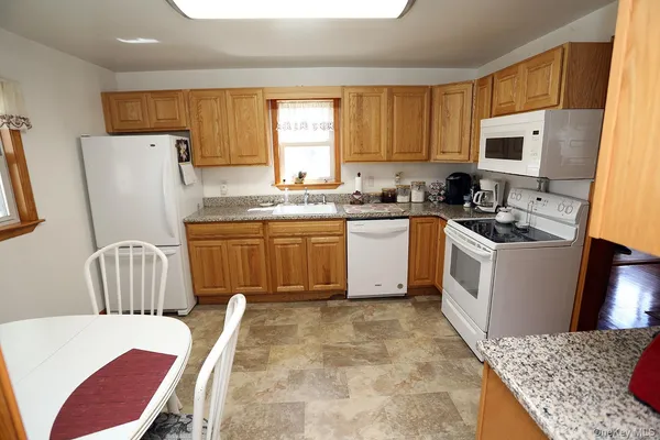 a kitchen with a sink a stove a refrigerator a microwave oven with granite countertops and cabinets