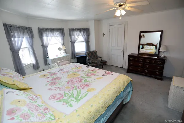 a bedroom with a bed and dresser with mirror