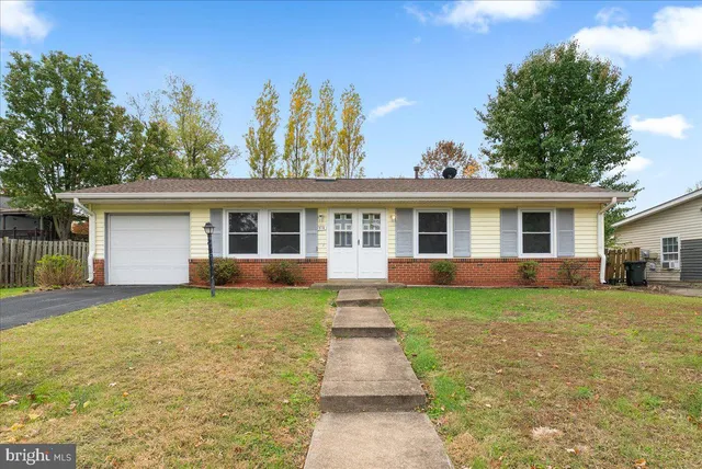 front view of a house and a yard with trees