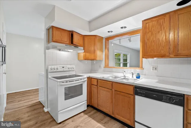 a kitchen with a stove sink and cabinets