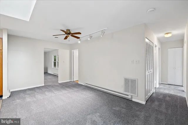 a view of an empty room with a ceiling fan