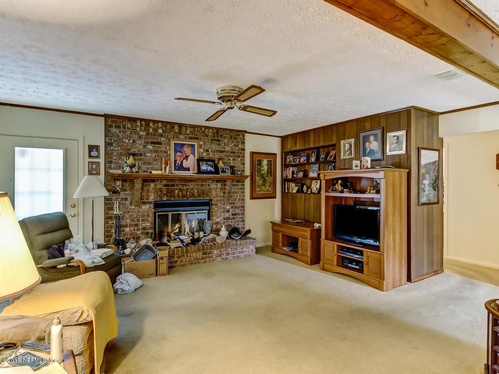 5527 Kennerly Road Jacksonville, FL 32207 - Photo 3 of 31 a living room with furniture a flat screen tv and a fireplace