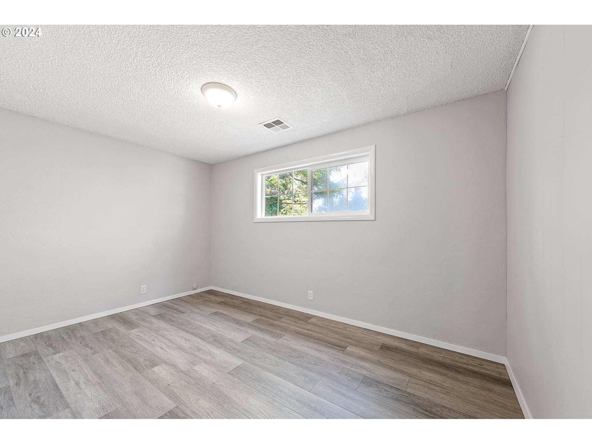 2697 Villa Way Springfield, OR 97477 - Photo 24 of 34 an empty room with wooden floor and windows