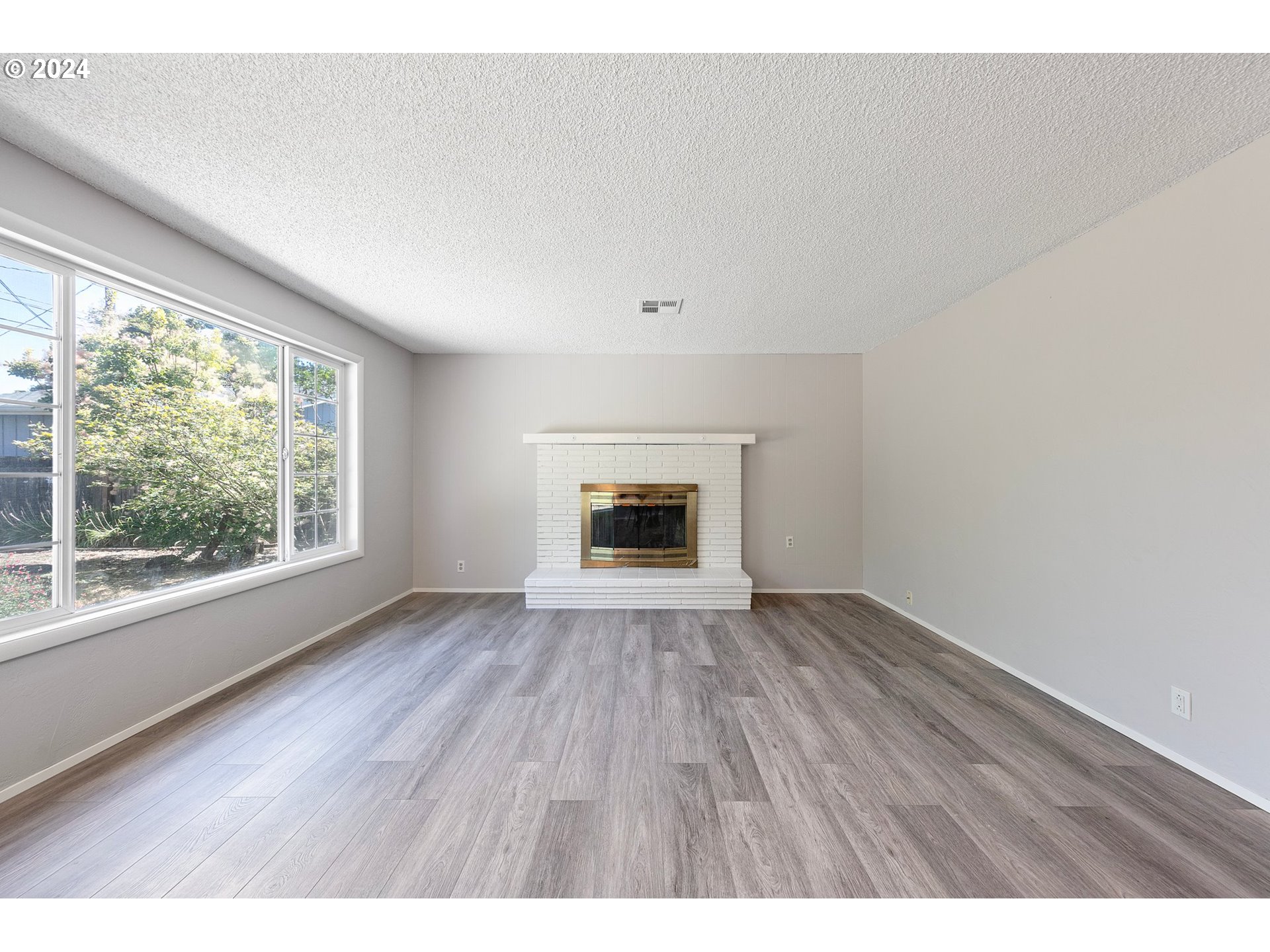 2697 Villa Way Springfield, OR 97477 - Photo 8 of 34 a view of an empty room with wooden floor and a window