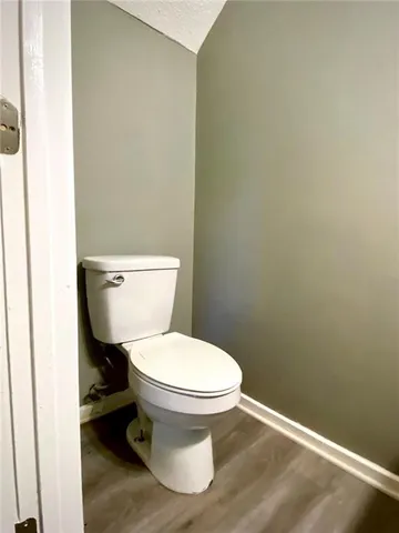 a white toilet sitting next to a white wall