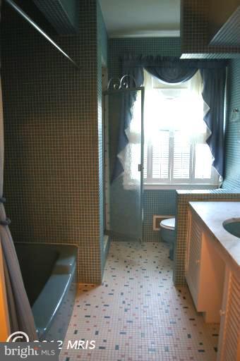 711 Stags Head Road Baltimore, MD 21286 - Photo 22 of 30 a bathroom with a granite countertop sink a toilet and shower