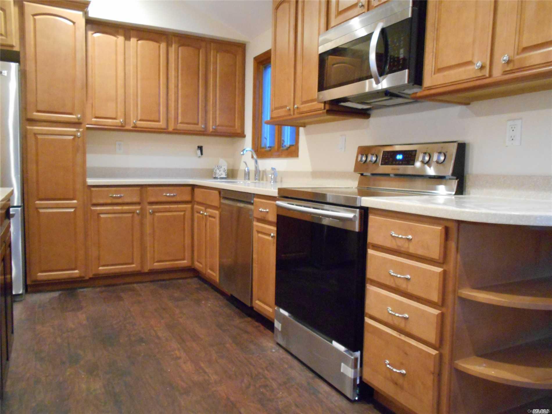 9 Ridge Haven Drive Ridge, NY 11961 - Photo 1 of 1 a kitchen with stainless steel appliances granite countertop a sink stove and microwave