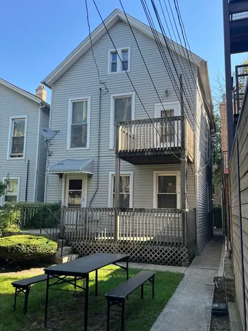 a view of a house with a wooden deck and furniture