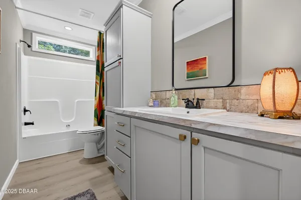 a bathroom with a granite countertop sink mirror vanity and toilet